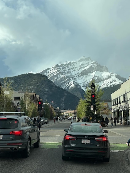A street with cars, a traffic light, and a mountain in the background. 5