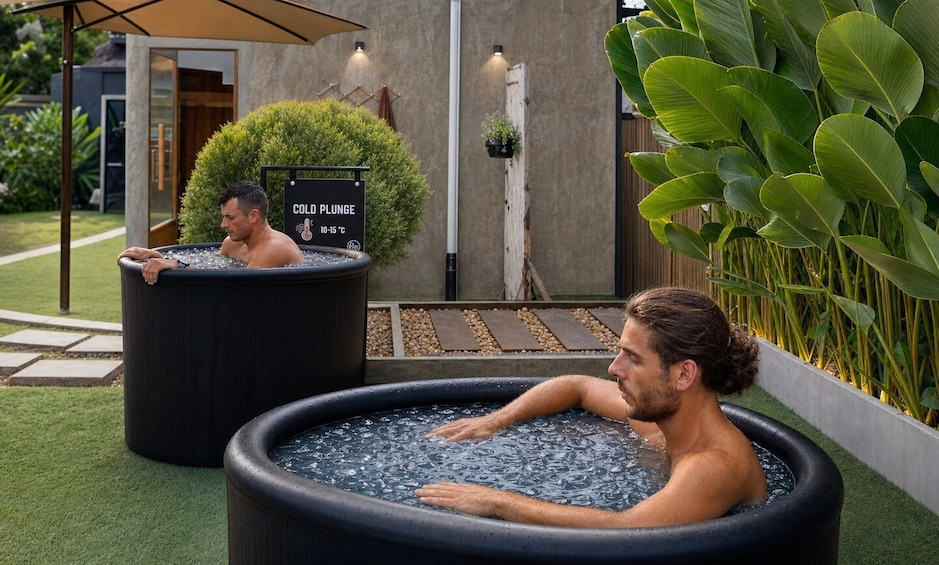Two individuals relaxing in large outdoor hot tubs with a sign indicating a temperature of 10-15°C. 4