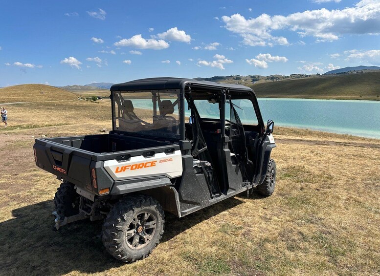 A UFORCE 1000 XL off-road vehicle parked on a grassy field near a lake. 4