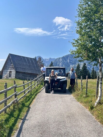 A rural road with a wooden fence, a small building, and a vehicle. 3