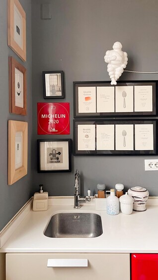 A kitchen with a sink, framed certificates, and a red sign. 2