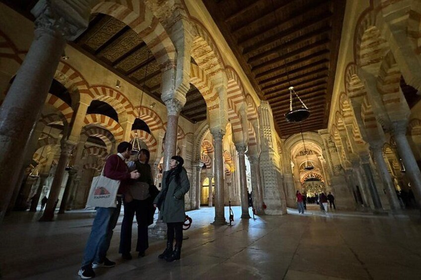 An interior with arches, columns, and a wooden ceiling. 5