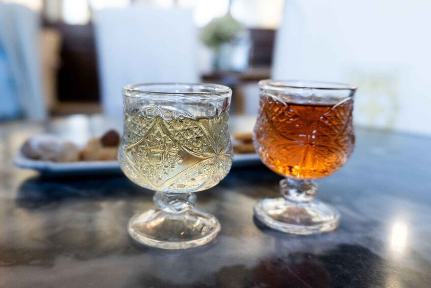 Two glasses of a clear and an amber-colored beverage on a table. 4