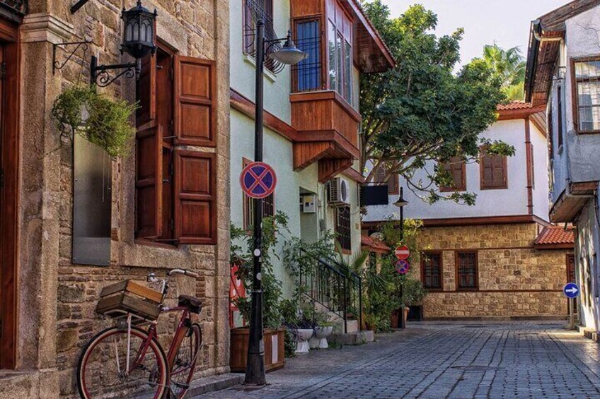 A cobblestone street lined with traditional buildings, a bicycle, and a no parking sign. 5