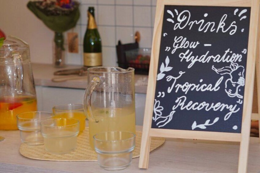 A beverage stand with a sign that reads 'Drinks Glow Hydration Tropical Recovery.' 2