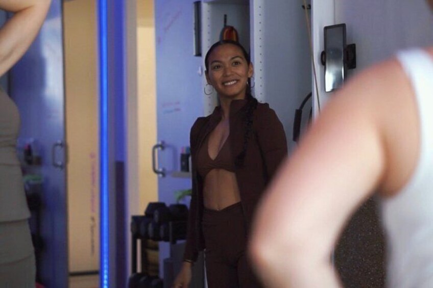 A person in workout attire in a gym with exercise equipment and a mirror. 1
