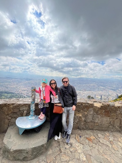 A family standing on a stone platform with a cityscape in the background. 5