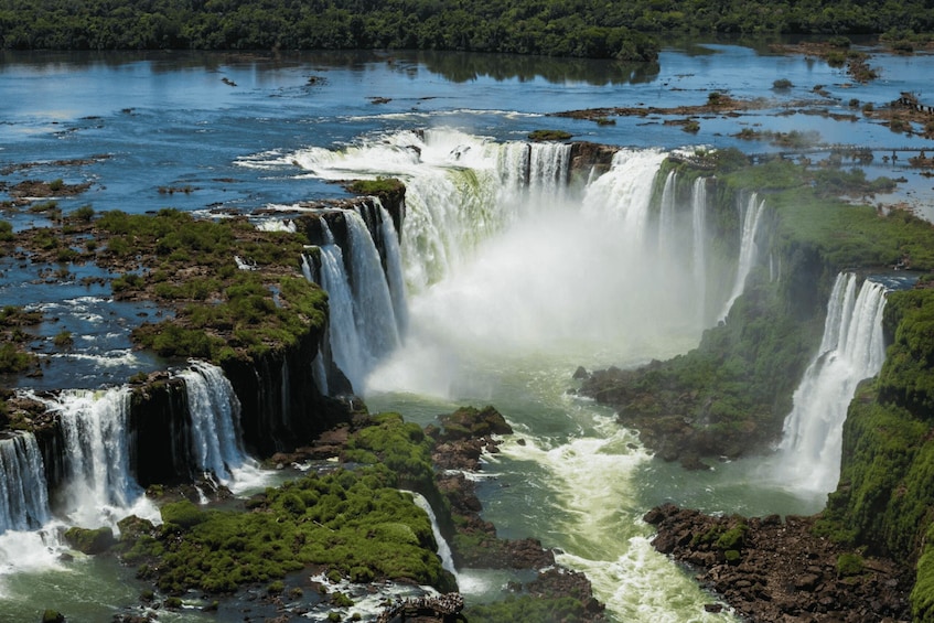 A large waterfall surrounded by lush greenery. 1