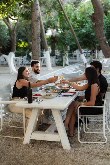 A group of people dining outdoors at a table with food and drinks. 5