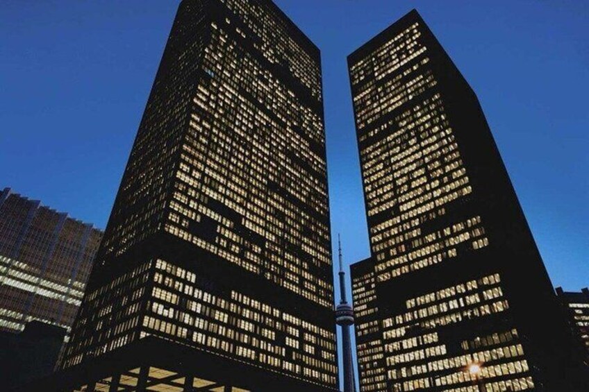 Two tall, illuminated skyscrapers with a clear sky in the background. 2