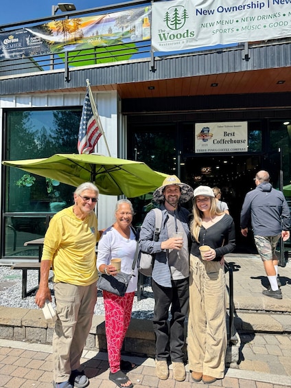 A group of people standing outside a restaurant with an American flag and a sign indicating it's a 'Best Coffeehouse'. 1