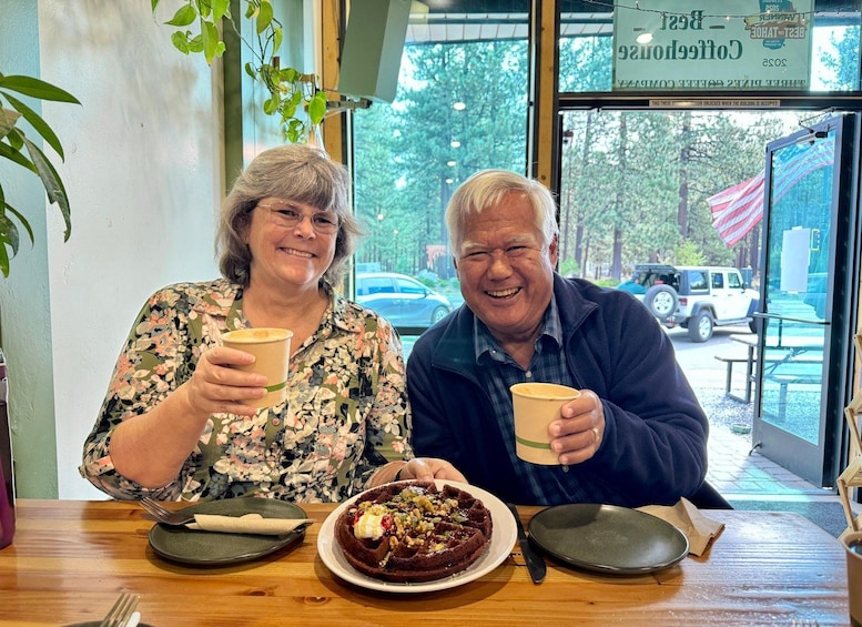 Two people sitting at a table with a plate of food and drinks. 4