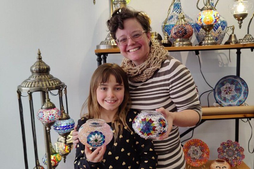 A person holding a decorative glass object with a child. 1