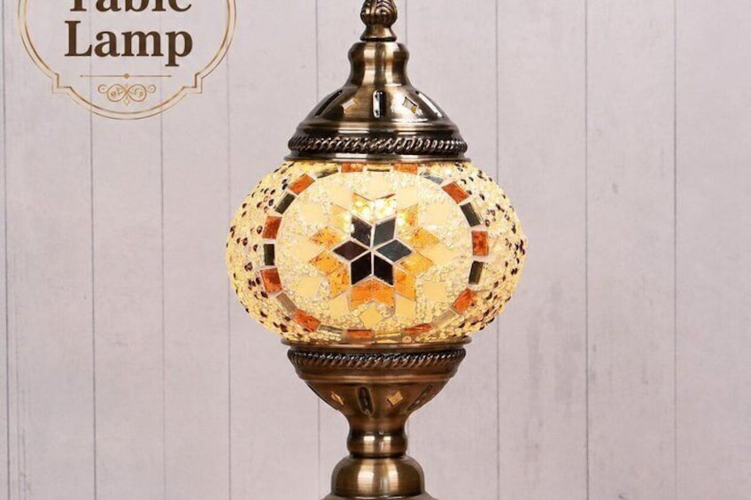 A decorative table lamp with a mosaic pattern and a brass base. 3