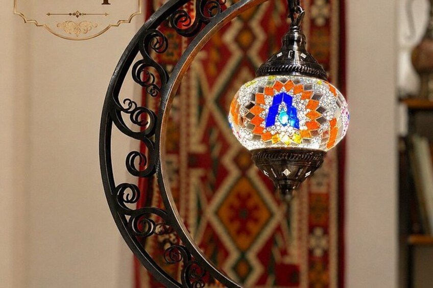 A decorative hanging lamp with a mosaic design and a letter 'A' in blue. 3