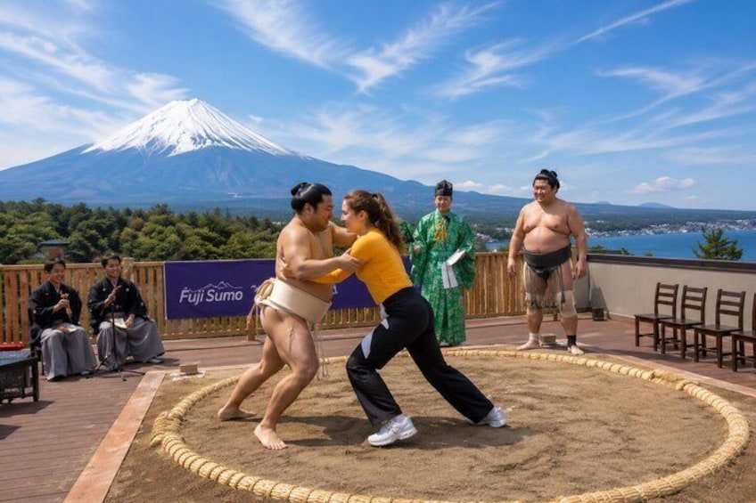 Two sumo wrestlers in a ring, with a mountain in the background. 3