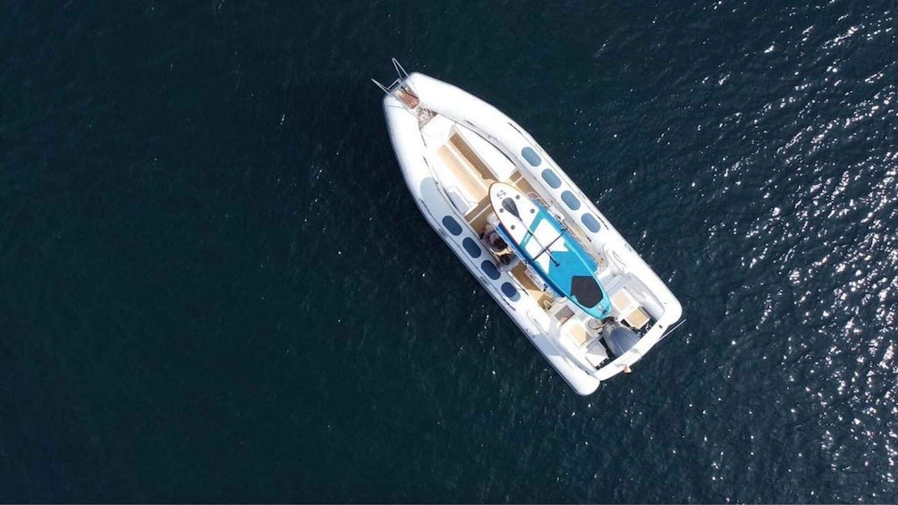 A white boat with a blue interior, floating on dark blue water. 4