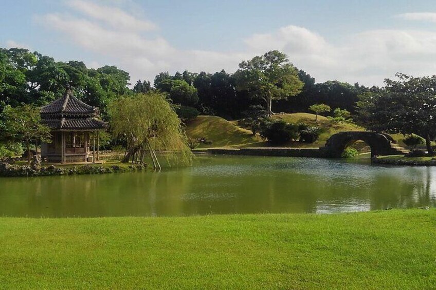 A tranquil pond with a gazebo, a willow tree, and a stone bridge. 5