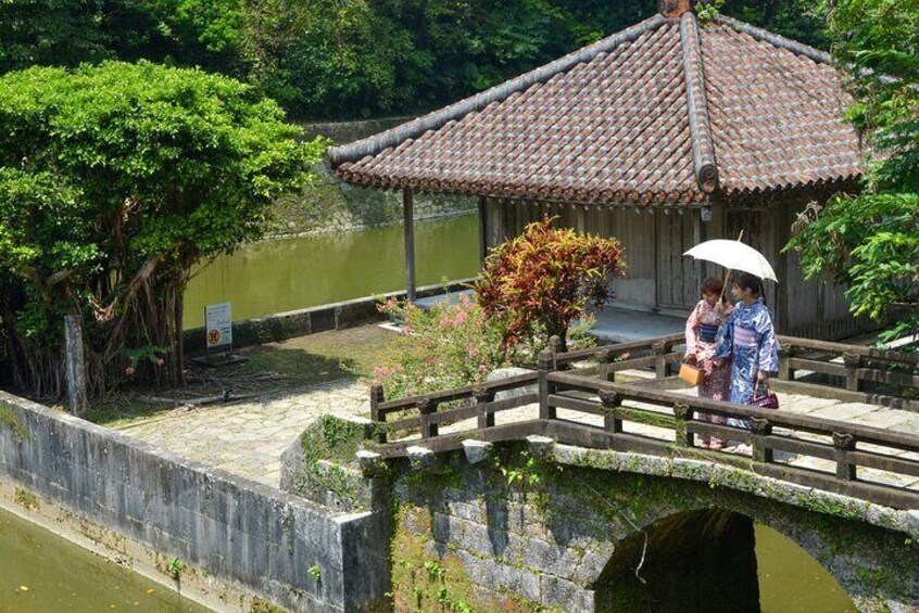 A traditional Japanese bridge, a wooden structure with a tiled roof, over a body of water. 1