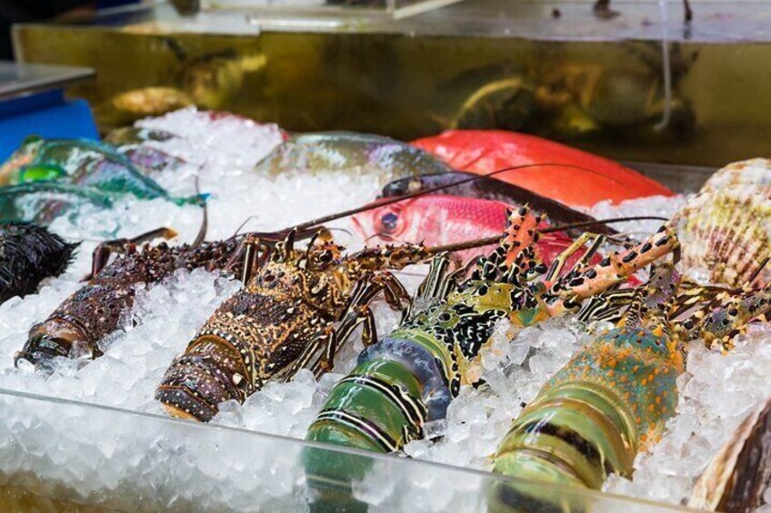 Lobsters on ice with a red fish and seashells. 2