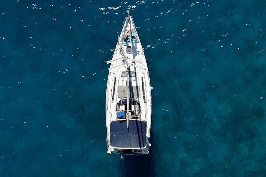 Una barca bianca con un ponte blu che naviga in acque cristalline. 2