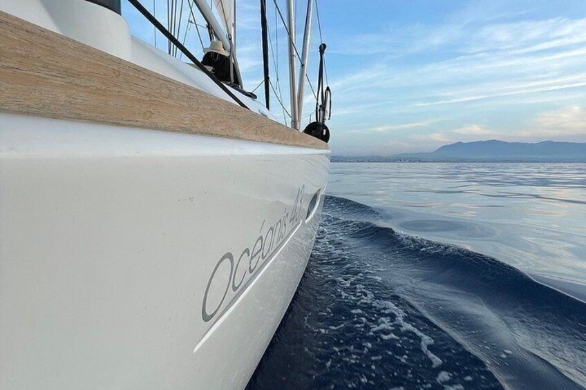 Un'imbarcazione con la scritta 'Oceans' sul fianco, circondata da schizzi d'acqua e con un cielo sereno. 5