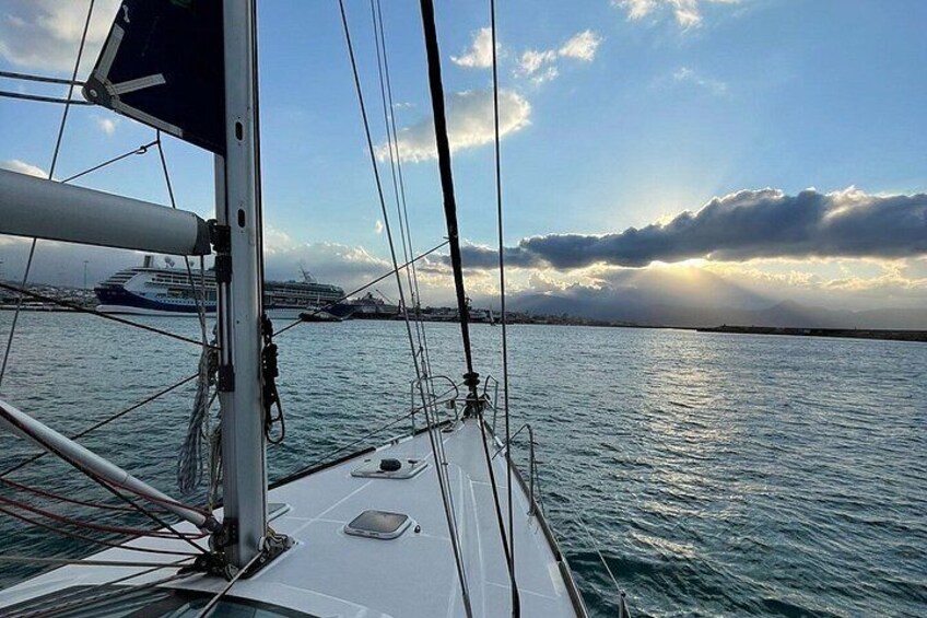 Una barca a vela con vista sul mare e una nave da crociera in lontananza. 3