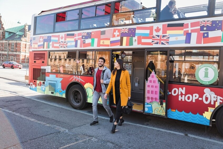 Un autobus à deux étages orné de drapeaux internationaux et portant l’inscription « ON » (pour indiquer qu’on peut descendre). 2