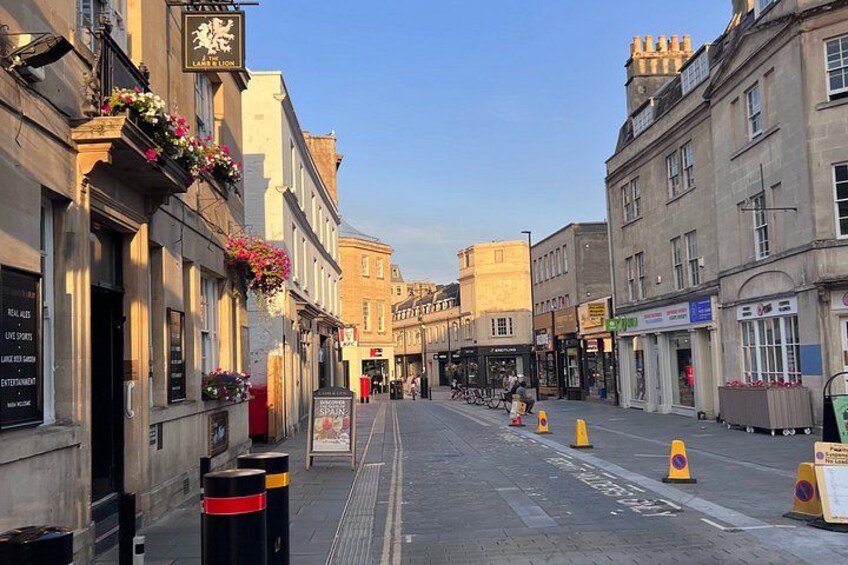 A street with buildings, bollards, and flower boxes. 3