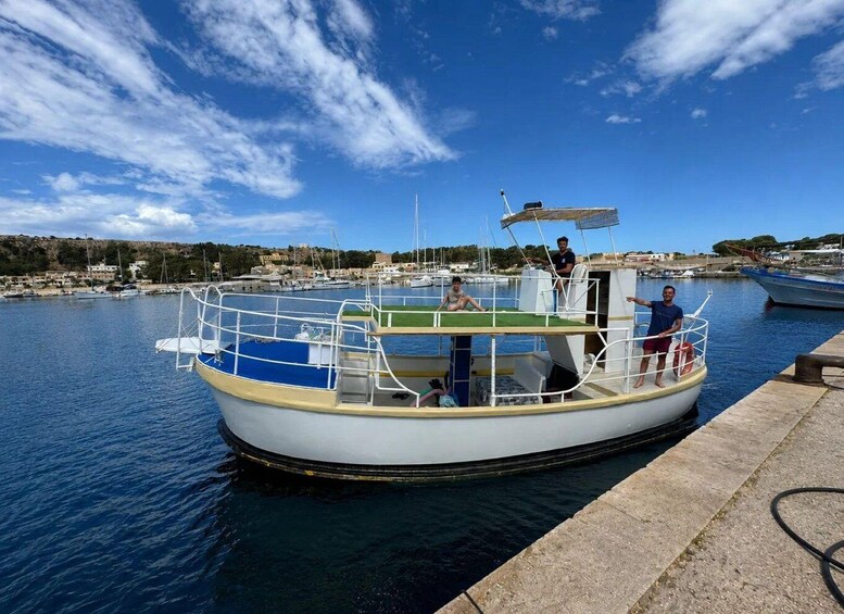 A boat docked at a marina with people on board and a clear sky. 4