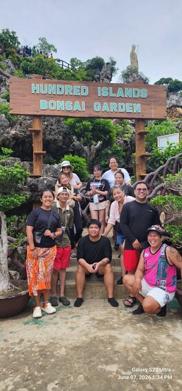 Ryhmä ihmisiä Hundred Islandsin bonsaipuutarhassa. 4