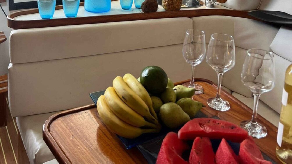 A tray with bananas, pears, a lime, and watermelon slices on a boat's deck. 4
