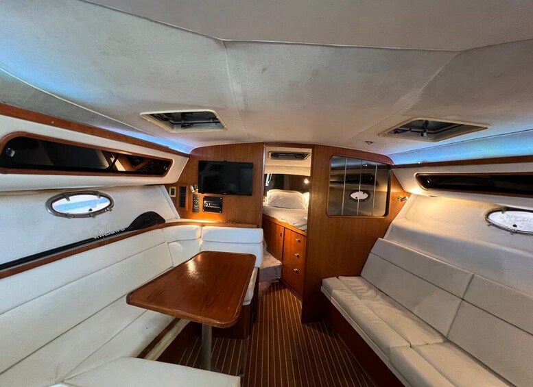 A yacht interior with a dining area, a sofa, and a TV. 5