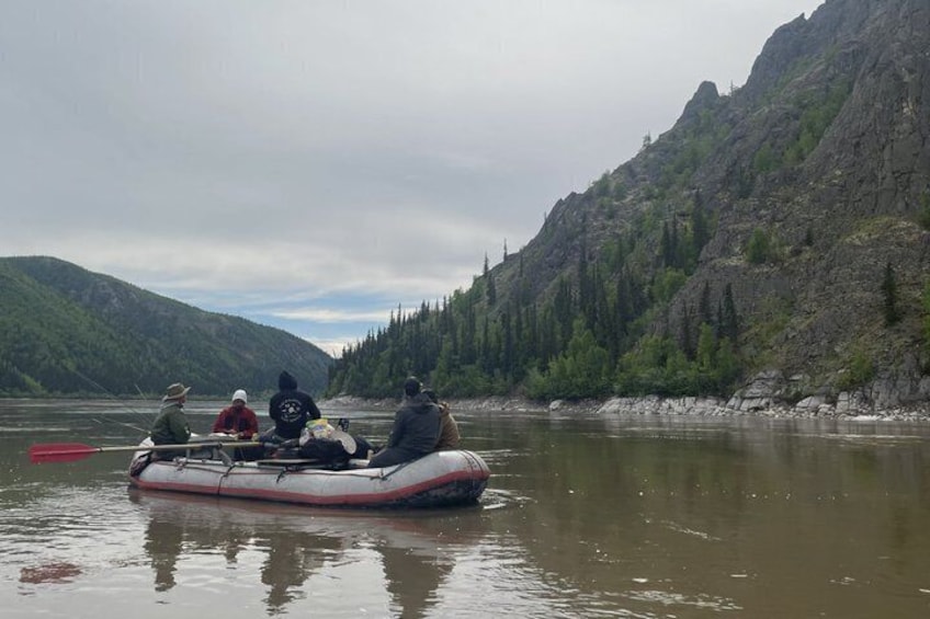 A group of people on a riverboat in a mountainous area. 2