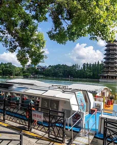A riverfront with a boat dock, a pagoda, and a bridge. 5
