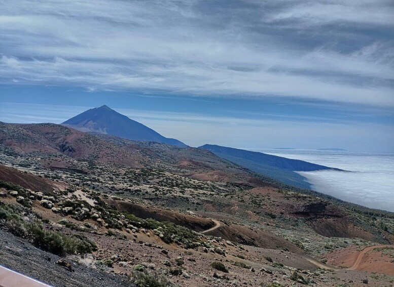 A mountainous landscape with a prominent peak, a winding road, and a coastal view. 3