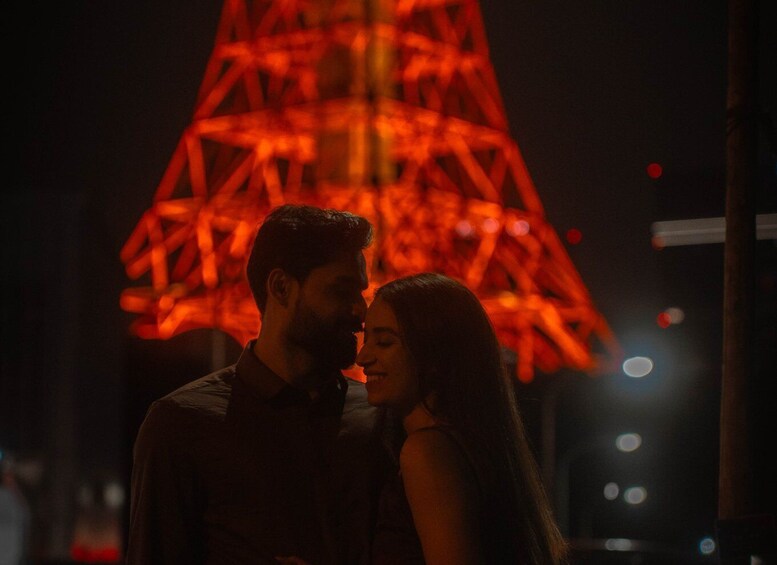 A couple standing in front of a brightly lit tower. 3