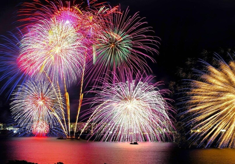 A nighttime fireworks display over a body of water with multiple bursts of light. 1