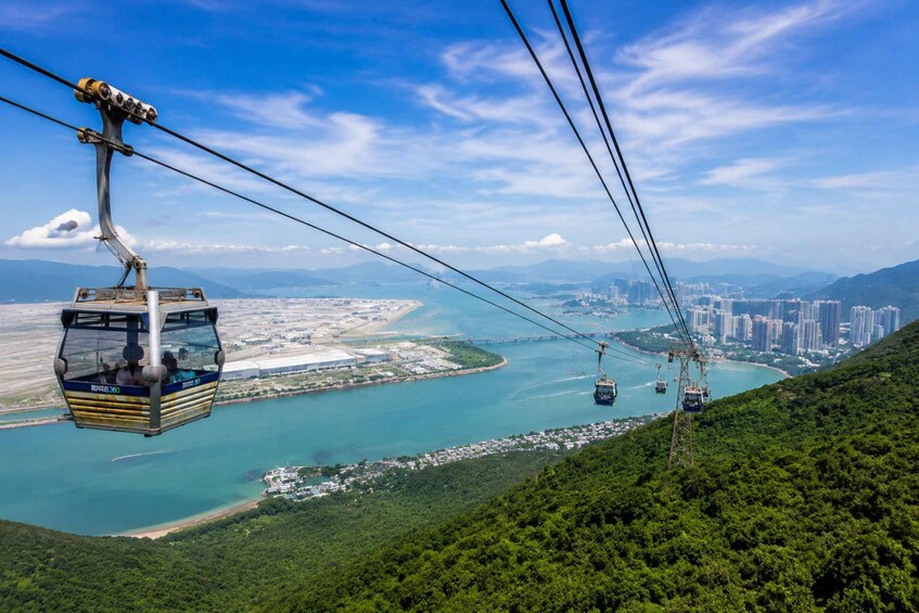 A cable car system with a view of a coastal city and mountains. 2