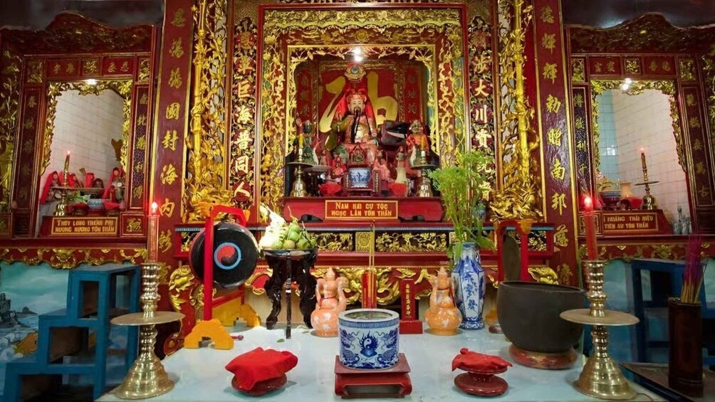 A traditional shrine with ornate decorations, a central figure, and ritual items. 5