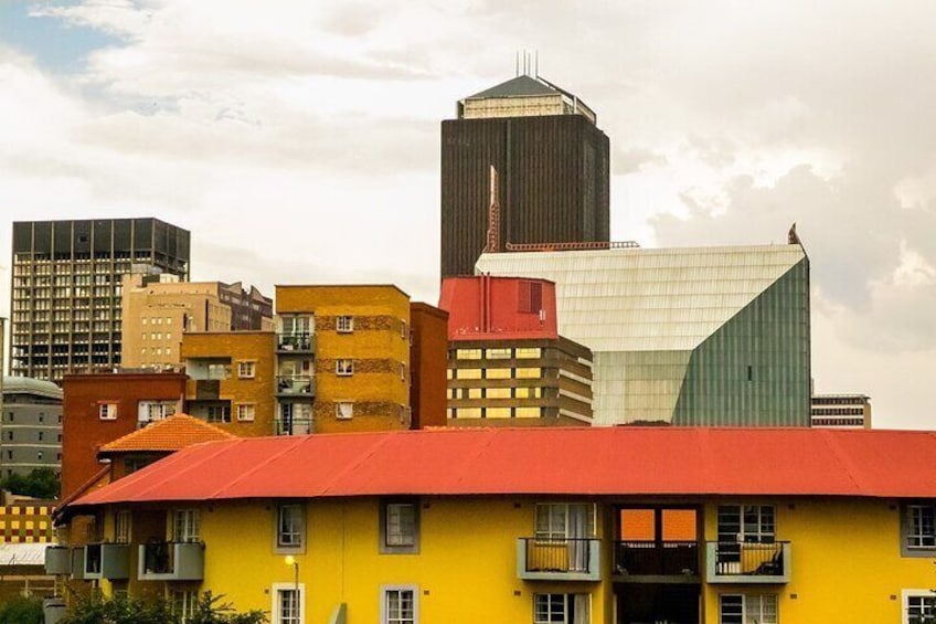 A cityscape with a prominent yellow building, a red-roofed structure, and a tall skyscraper. 5