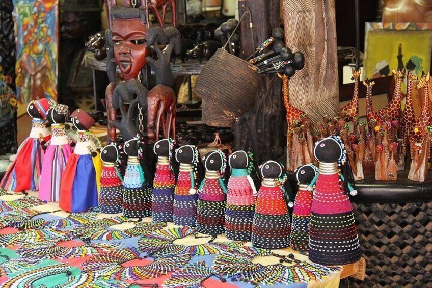 A display of colorful beaded dolls and figurines, possibly for sale. 3
