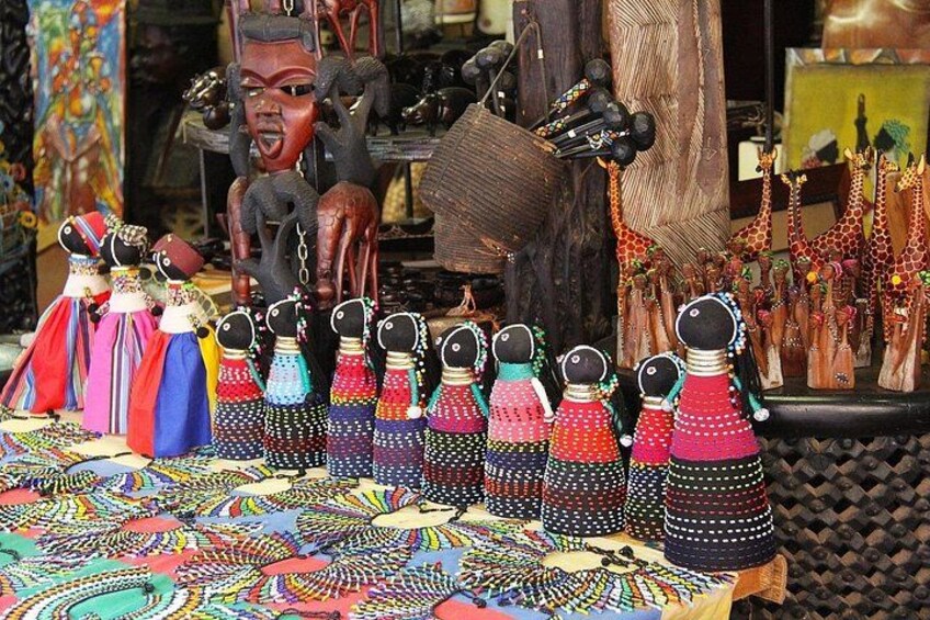 A display of colorful handcrafted dolls and beaded jewelry. 2