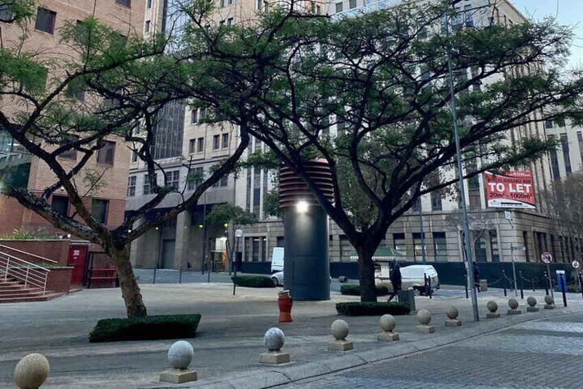 A tree-lined street with bollards, a 'To Let' sign, and a building in the background. 2