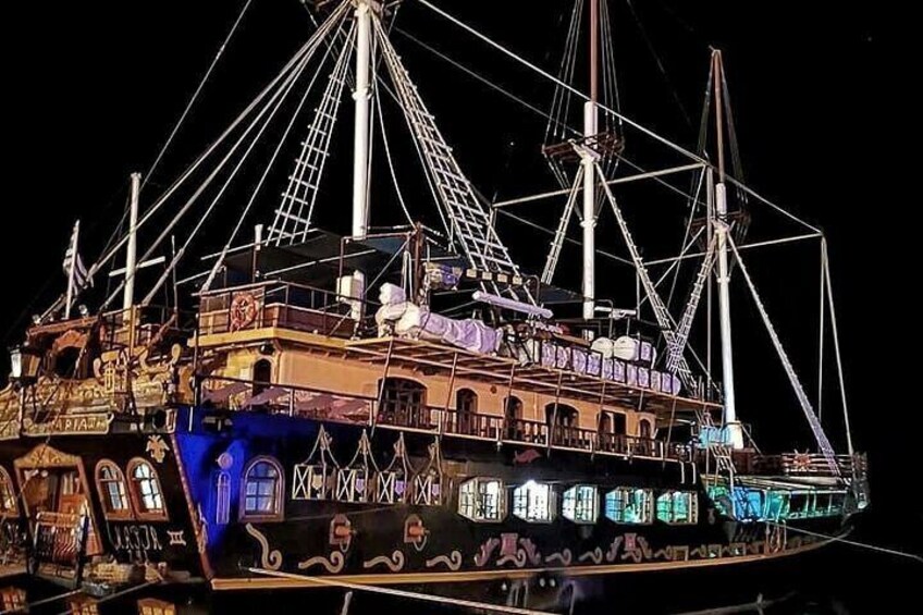 A large, illuminated ship with multiple decks and masts, decorated with lights and patterns. 5