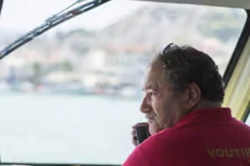 A person in a red shirt with 'YOUTH' on the back, sitting by a window on a boat. 3