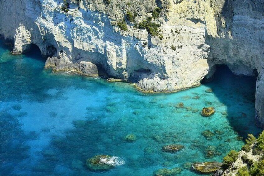 A coastal cliff with clear turquoise waters and a rocky outcrop. 4