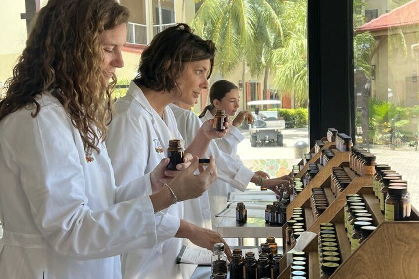 Three individuals in white lab coats examining jars of products on a display counter. 4
