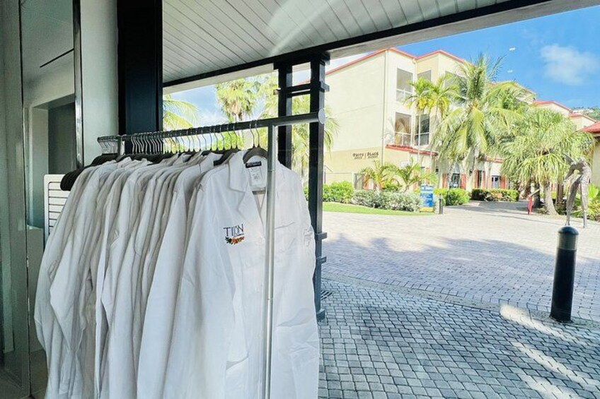 A white shirt hanging on a rack, a building with a sign, and palm trees in the background. 4