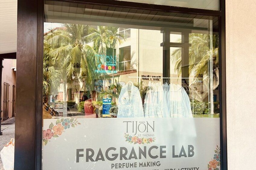 A storefront with a sign for 'Tijon Fragrance Lab' and a display of perfume bottles. 3